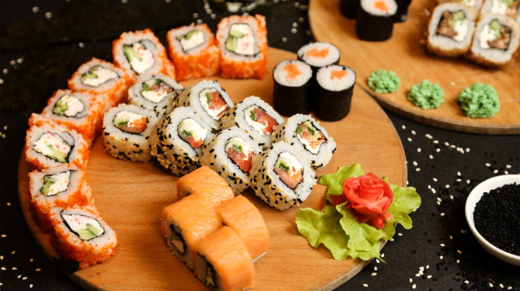 Un assortiment de sushis, avec du gingembre, du wasabi et des graines de sésame sur une table en bois